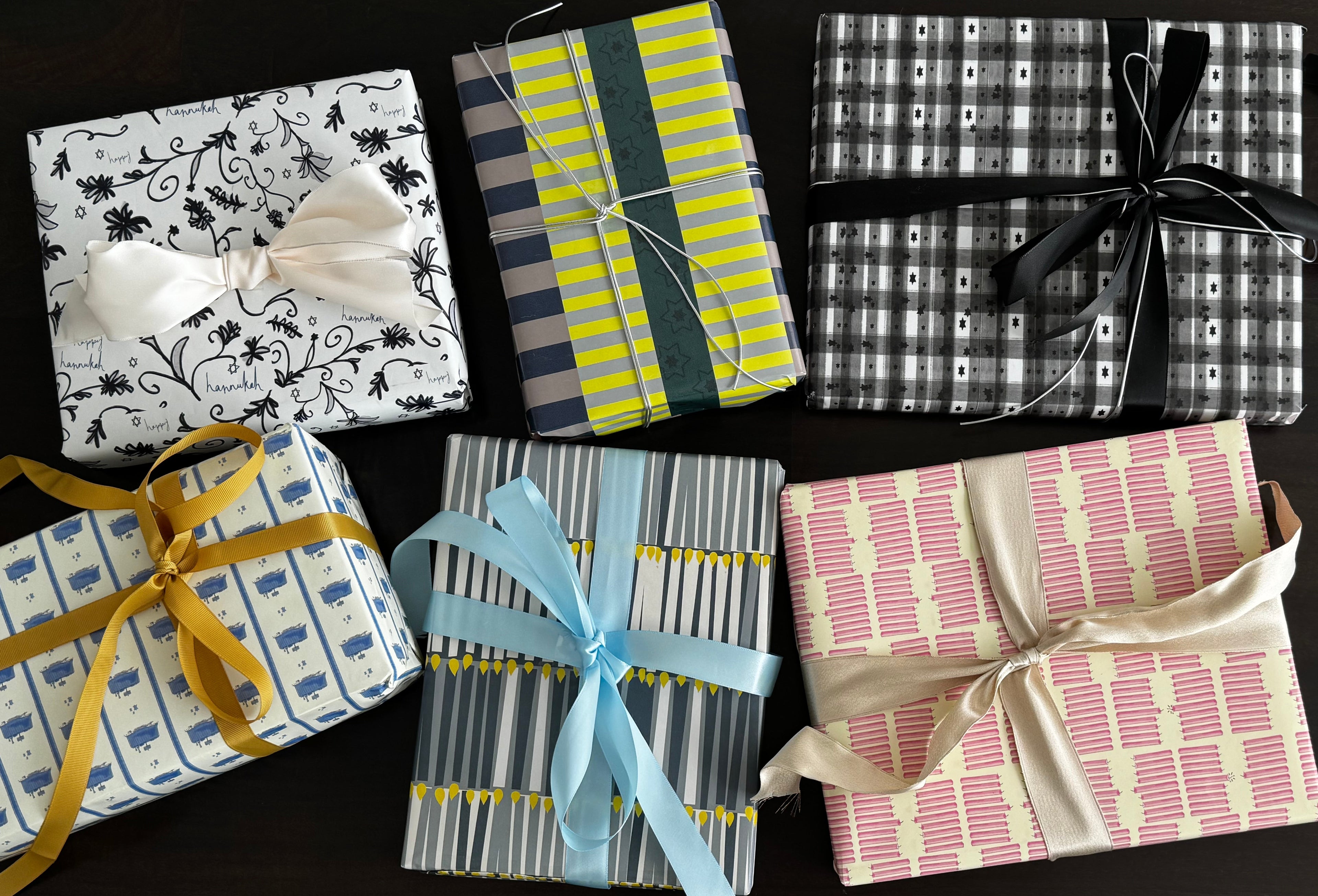 Collection of Hanukkah and Jewish Gift Wrapping boxes with various patterns and ribbons on a dark surface
