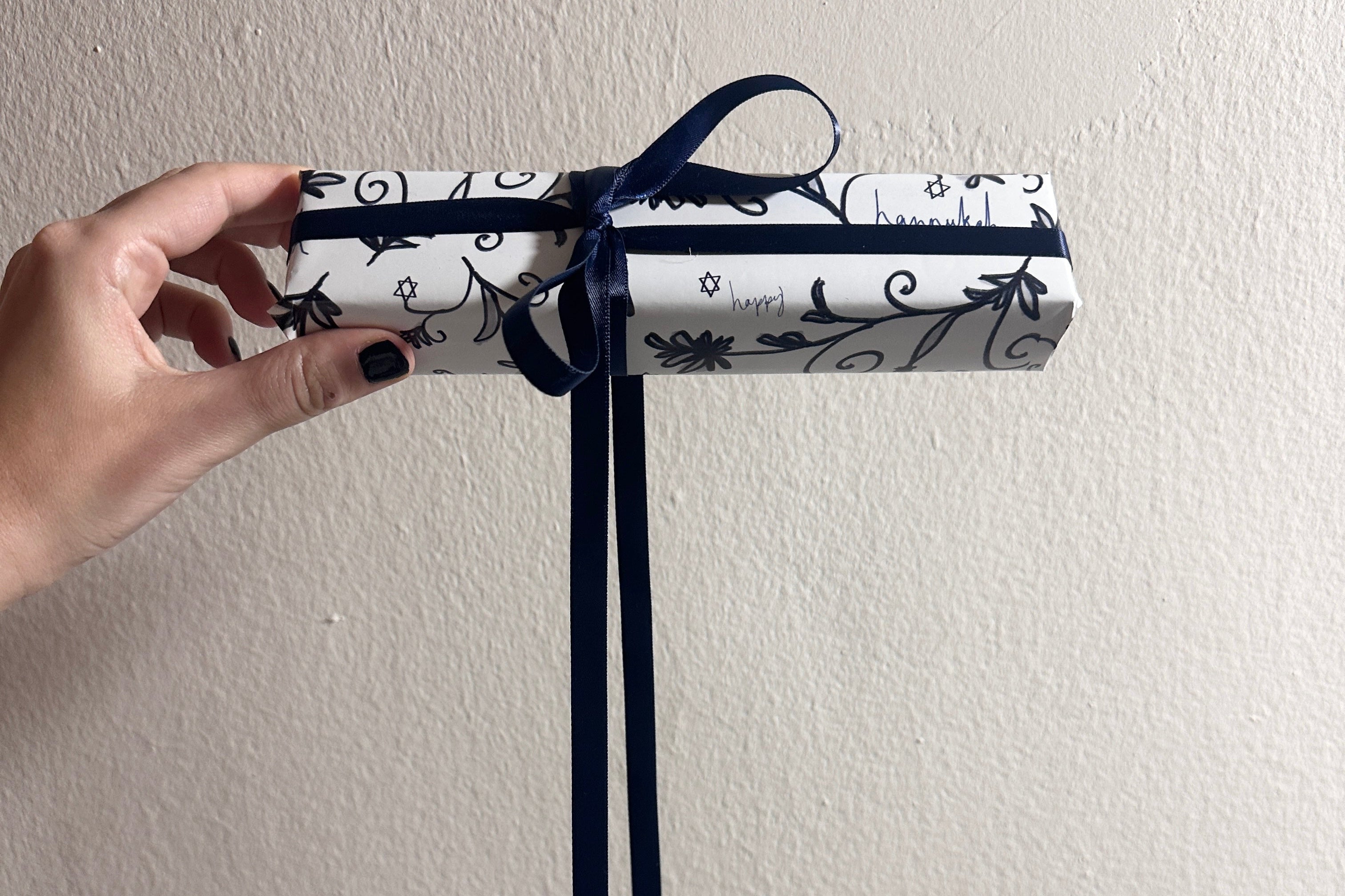Chic, modern, design-forward hanukkah gift wrapping with a bow